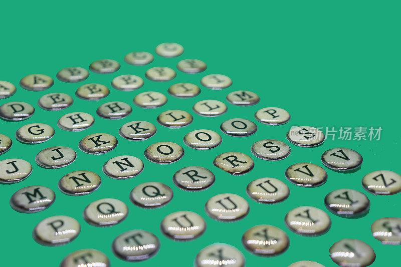 字母J, K, M, N, P, Q, T的大写字母，像打字机的按键一样，在纯绿色的背景上